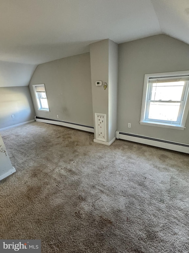 additional living space with a baseboard heating unit, lofted ceiling, and carpet floors