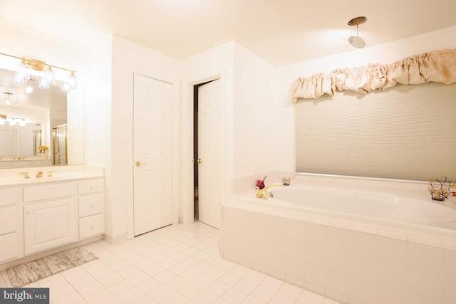 bathroom featuring tile patterned floors, a shower with door, a bath, and vanity