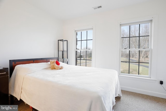 carpeted bedroom with visible vents and baseboards