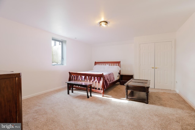 bedroom with baseboards, carpet floors, and a closet