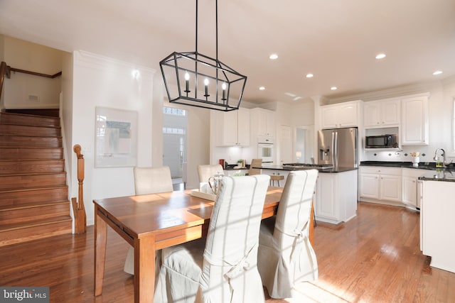 dining area featuring recessed lighting, light wood-style flooring, stairs, and ornamental molding