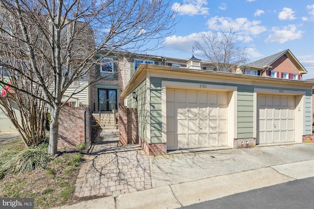 view of front of property featuring community garages, an outbuilding, and brick siding