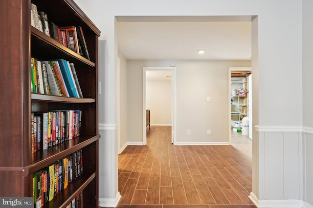 hallway with baseboards and wood finished floors