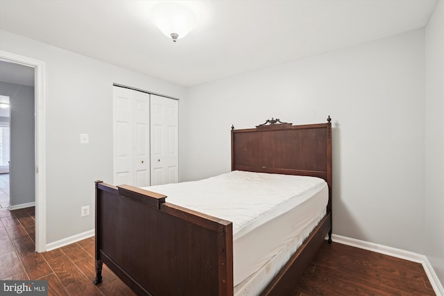 bedroom featuring dark wood-style floors, a closet, and baseboards