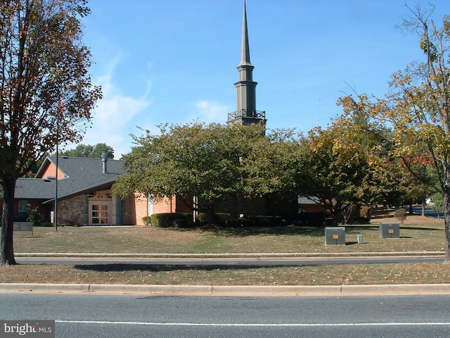 view of front facade featuring a front lawn and stone siding