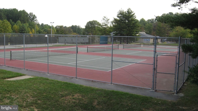 view of tennis court with a gate and fence