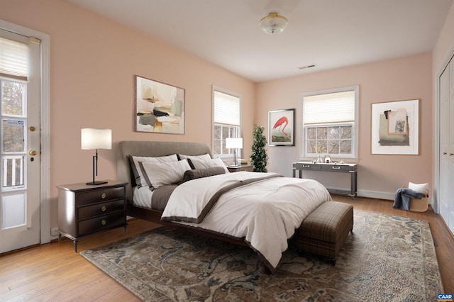 bedroom featuring visible vents, baseboards, and wood finished floors