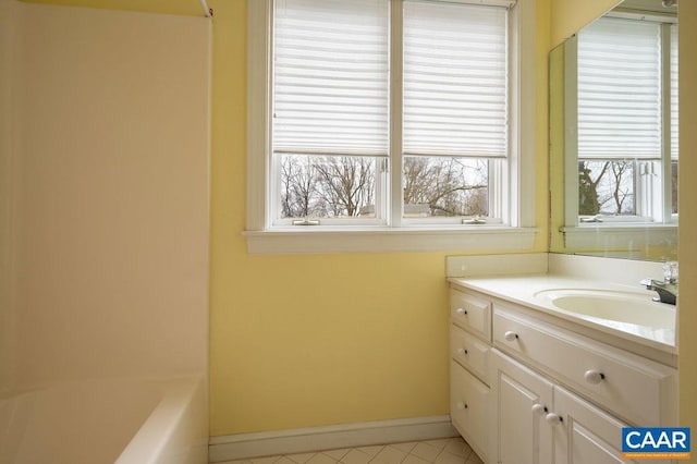 bathroom with tile patterned flooring, a tub, walk in shower, baseboards, and vanity