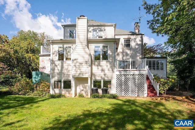 back of property featuring a lawn, a chimney, and stairs