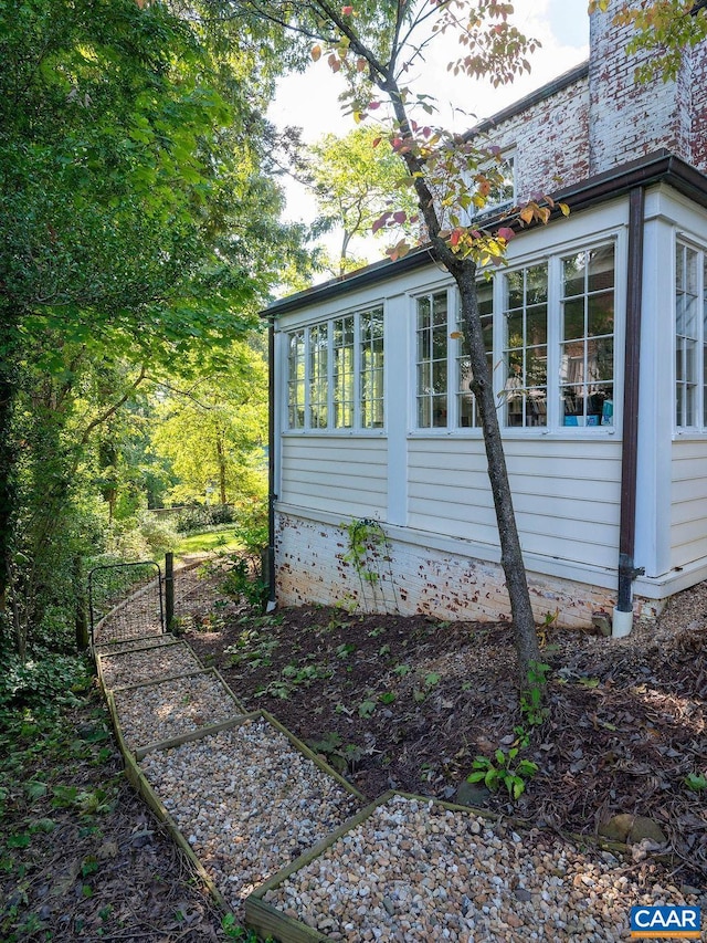 view of property exterior with a sunroom