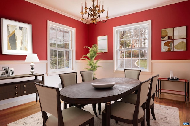 dining room featuring crown molding, an inviting chandelier, and wood finished floors