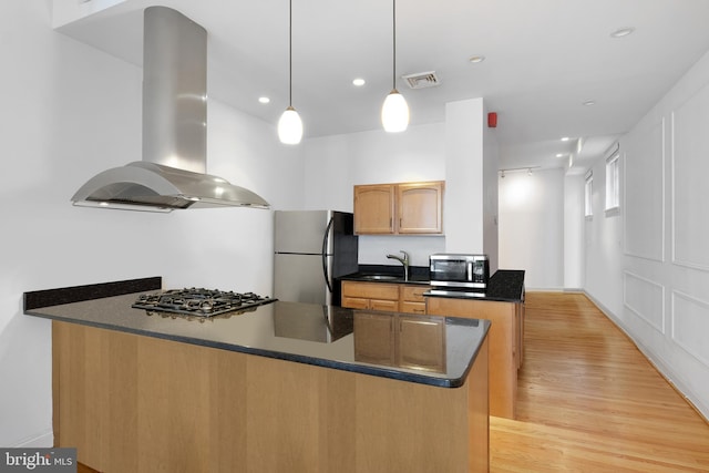 kitchen with a peninsula, visible vents, stainless steel appliances, and island range hood