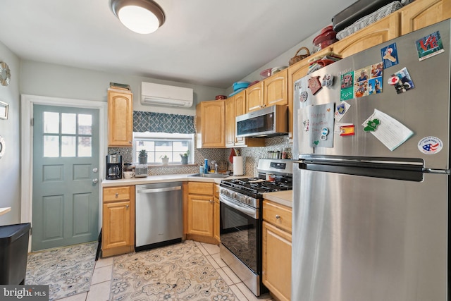 kitchen featuring a sink, decorative backsplash, light countertops, stainless steel appliances, and a wall mounted air conditioner