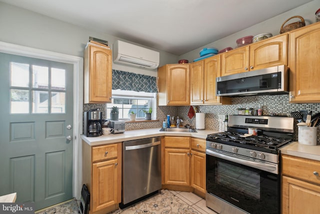 kitchen featuring backsplash, an AC wall unit, stainless steel appliances, and a sink