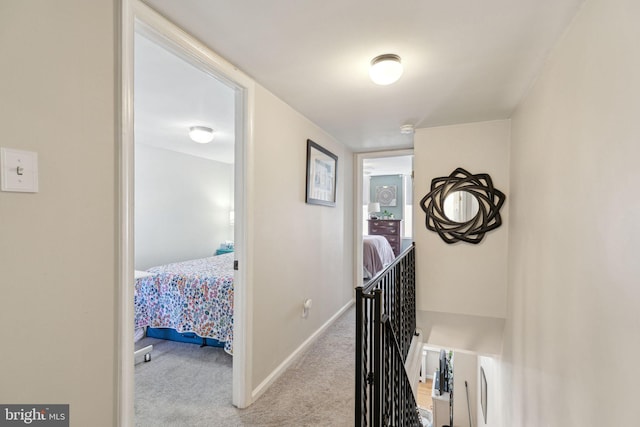 corridor featuring baseboards and carpet flooring