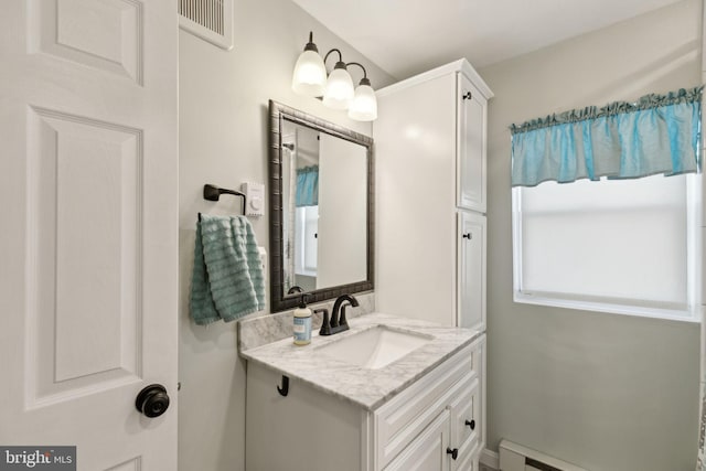 bathroom featuring visible vents, baseboard heating, and vanity