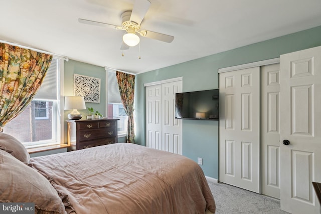 bedroom with carpet, multiple closets, and ceiling fan