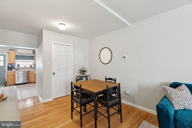 dining space with baseboards and light wood-type flooring