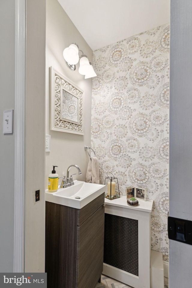 bathroom with vanity and wallpapered walls