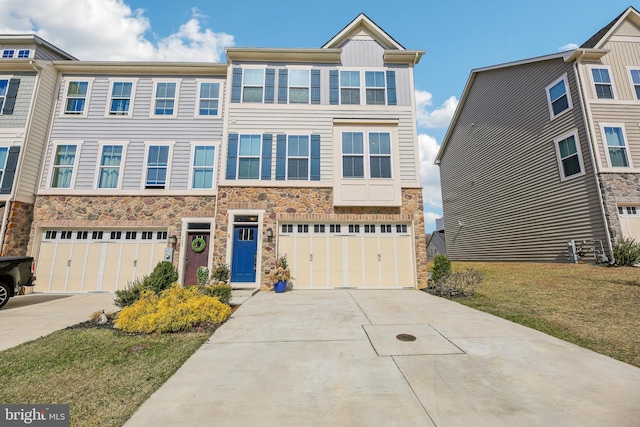 view of property with concrete driveway, an attached garage, and stone siding