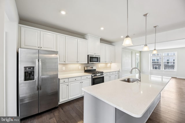 kitchen with decorative backsplash, white cabinets, appliances with stainless steel finishes, and a sink