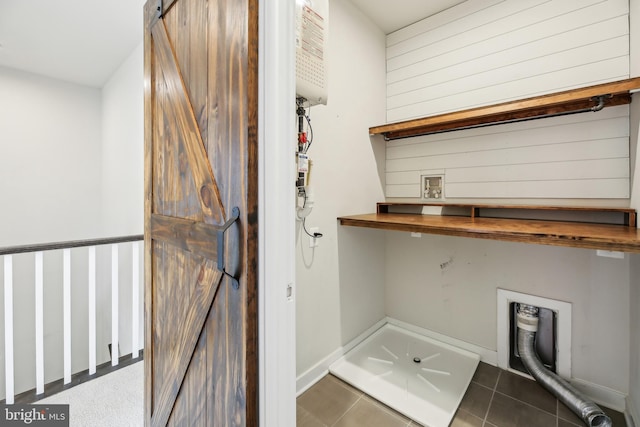 laundry area with tile patterned flooring, a barn door, hookup for a washing machine, and laundry area