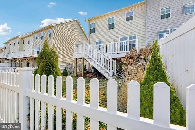 view of home's exterior featuring stairway, a residential view, and fence private yard