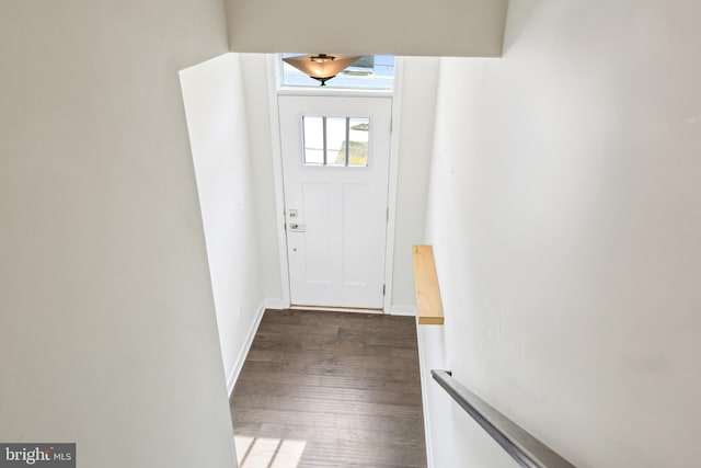 doorway featuring dark wood-type flooring and baseboards