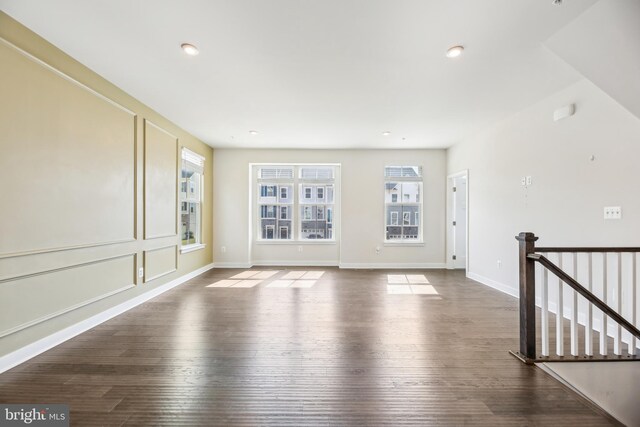 spare room featuring recessed lighting, wood finished floors, and baseboards