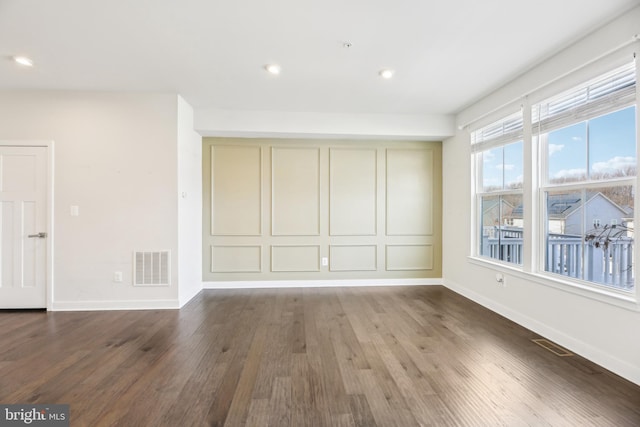 spare room with visible vents, recessed lighting, baseboards, and wood finished floors