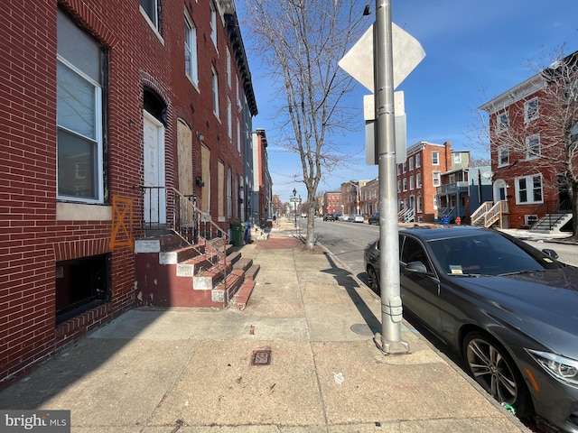 view of street with sidewalks, curbs, and street lights