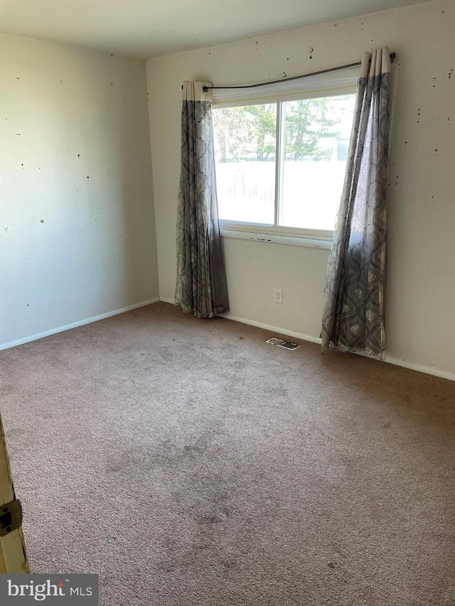 carpeted empty room with baseboards and visible vents