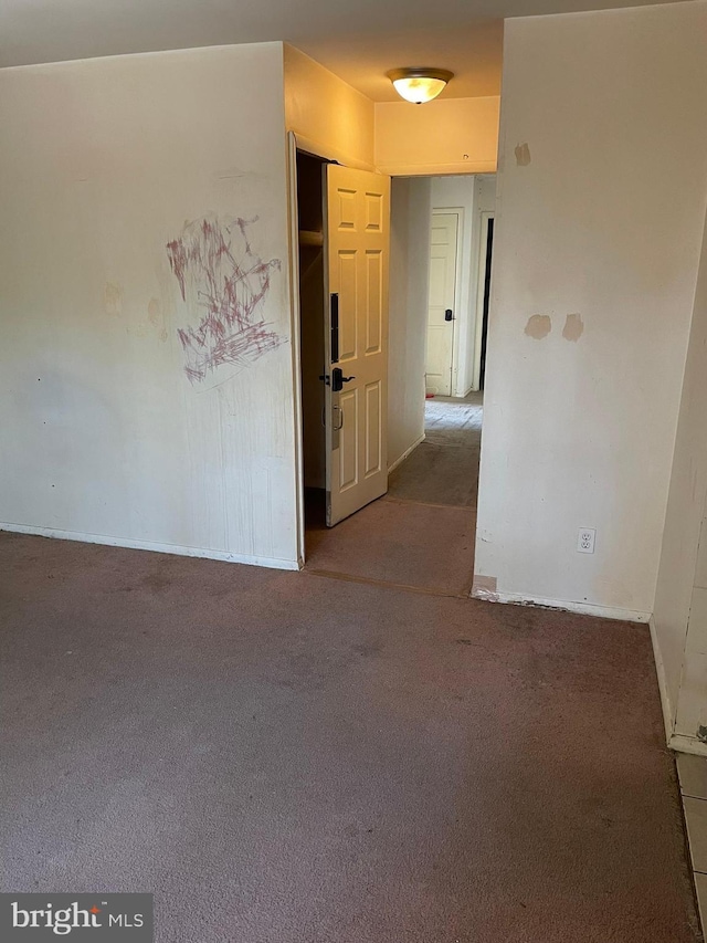 spare room featuring baseboards and carpet floors