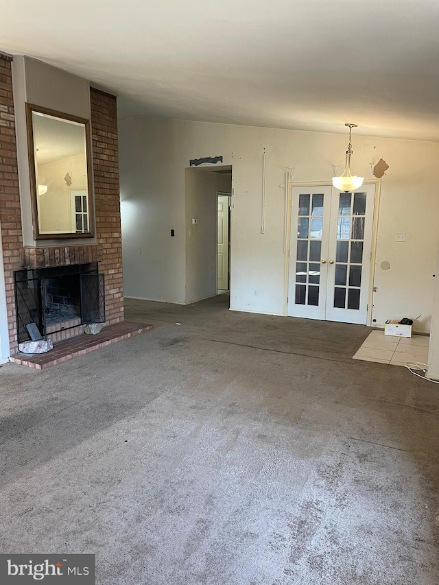 unfurnished living room featuring a fireplace, french doors, and carpet floors