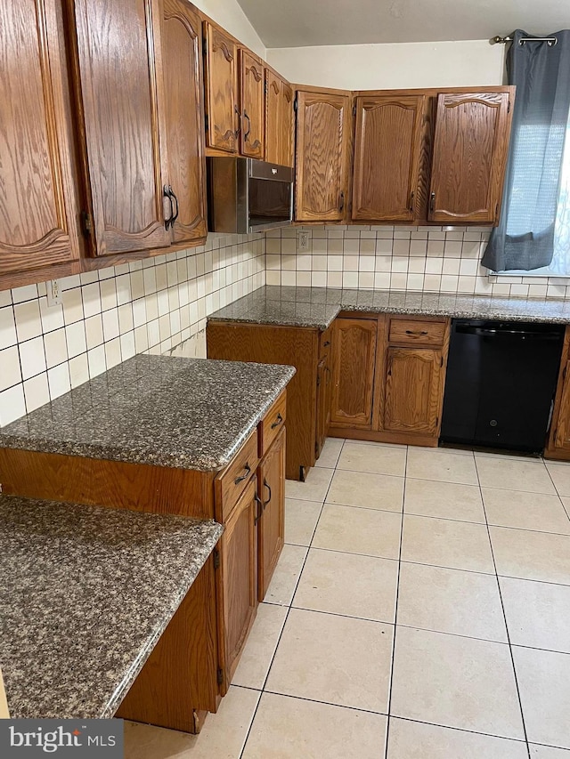 kitchen with dishwasher, dark stone countertops, light tile patterned floors, and tasteful backsplash