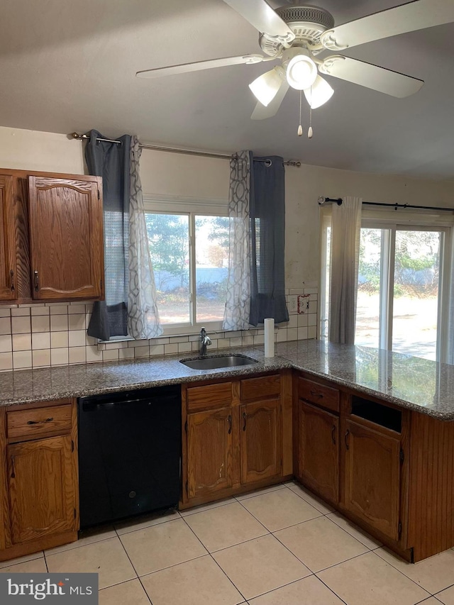 kitchen featuring a sink, backsplash, black dishwasher, and brown cabinetry