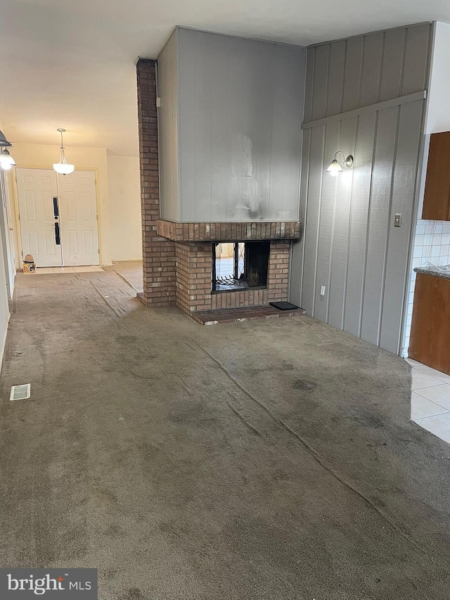 unfurnished living room with visible vents, carpet, and a fireplace