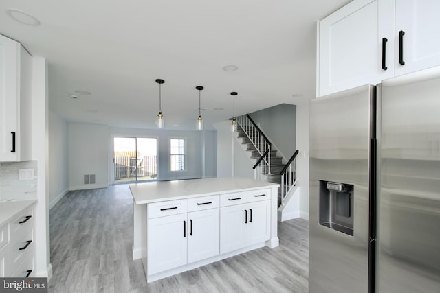 kitchen featuring visible vents, decorative backsplash, stainless steel fridge with ice dispenser, and light wood finished floors