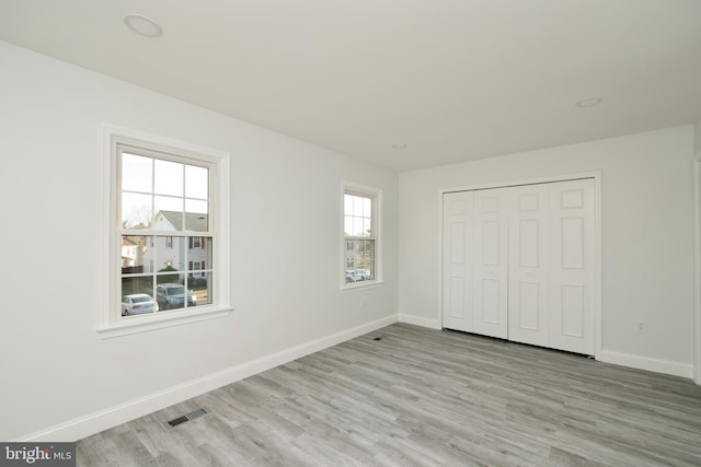 unfurnished bedroom featuring visible vents, baseboards, and light wood-style floors