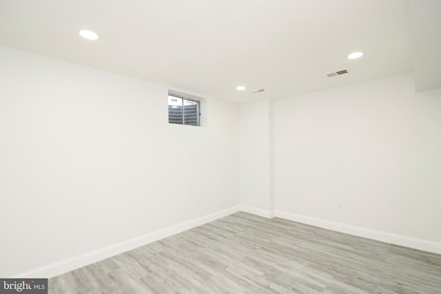 below grade area with visible vents, recessed lighting, wood finished floors, and baseboards