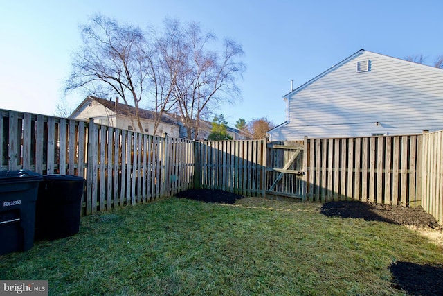 view of yard featuring a fenced backyard and a gate