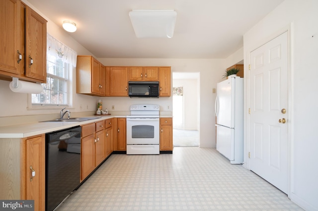 kitchen with black appliances, light floors, light countertops, and a sink