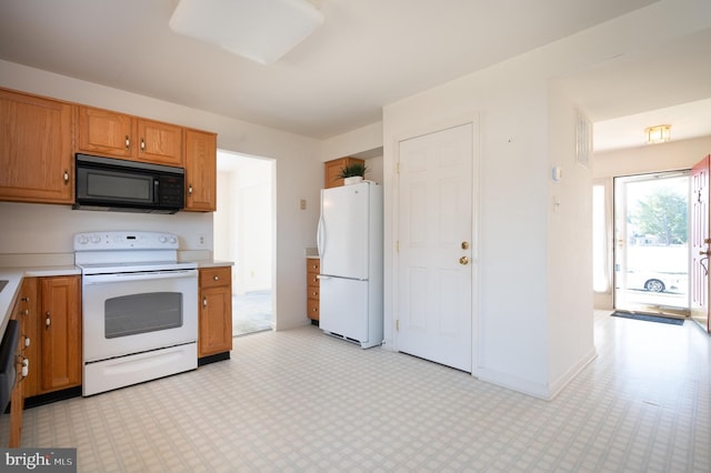 kitchen with white appliances, brown cabinetry, light floors, and light countertops