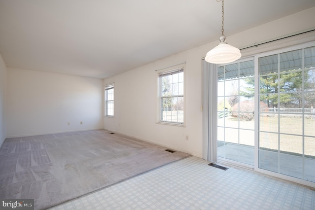 unfurnished room featuring visible vents, baseboards, and carpet