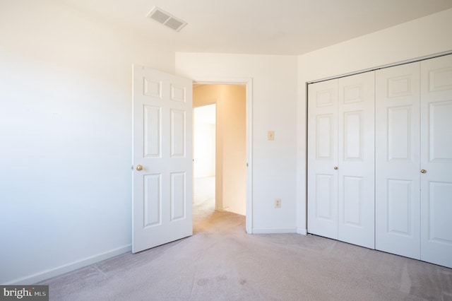 unfurnished bedroom featuring a closet, baseboards, visible vents, and carpet floors