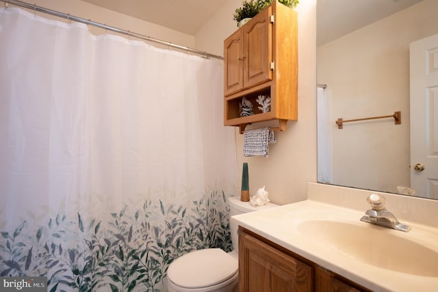 bathroom featuring curtained shower, toilet, and vanity