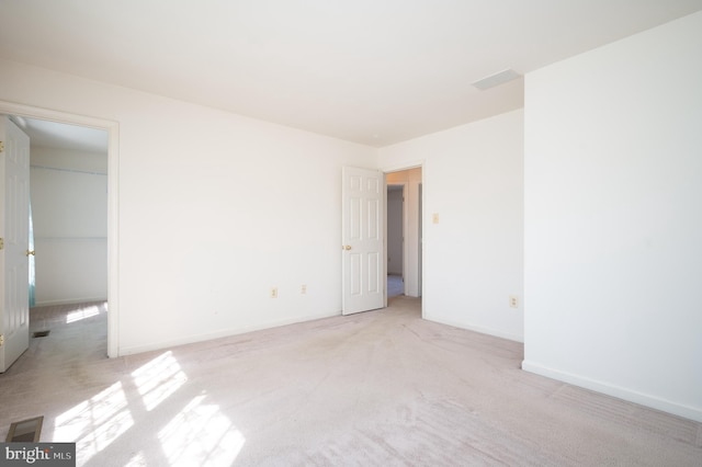 spare room with baseboards and light carpet