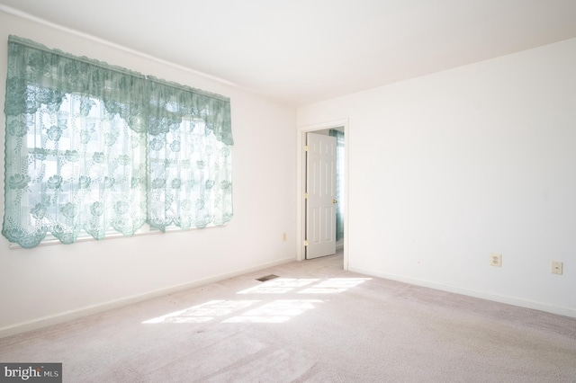 carpeted empty room featuring visible vents and baseboards