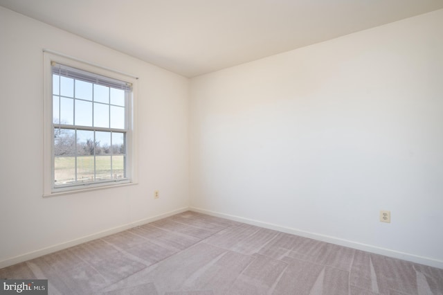 spare room with baseboards and light carpet