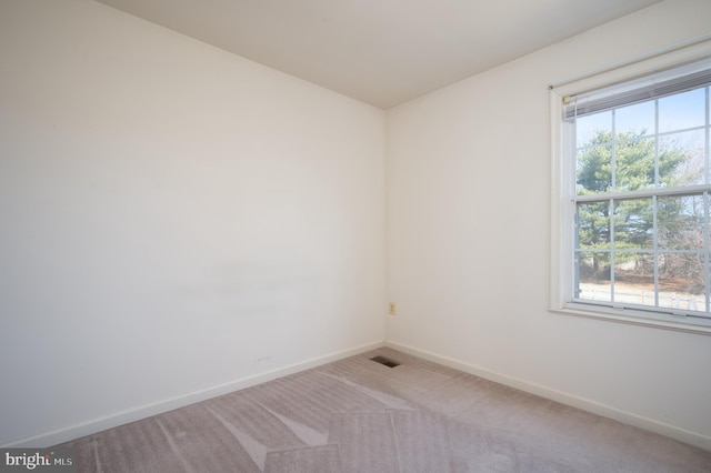 spare room with visible vents, baseboards, and light colored carpet